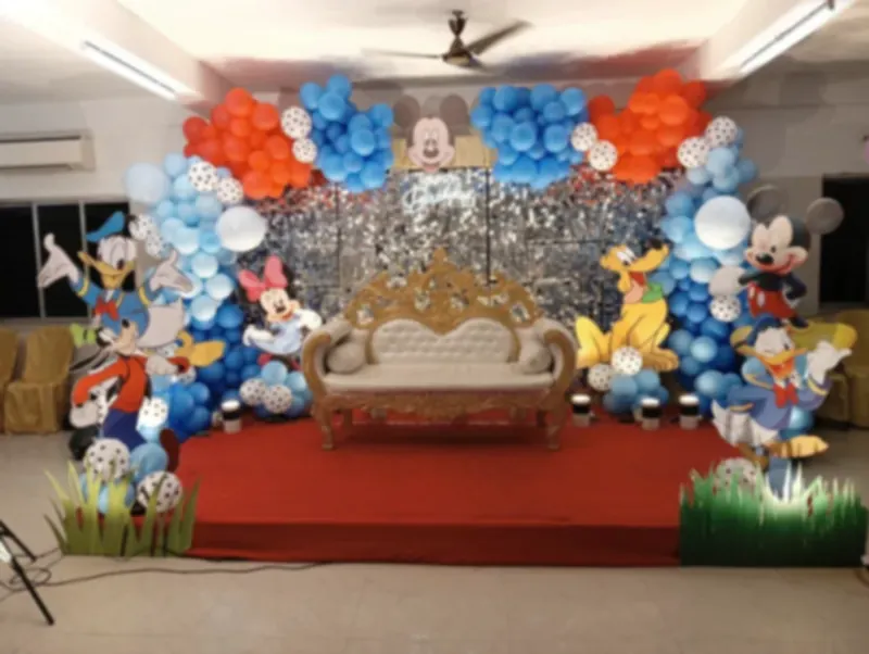 Children's birthday stage with a sequin backdrop and cartoon cut-outs