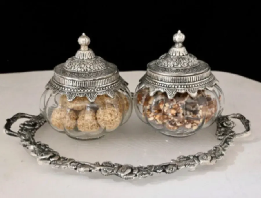 Two lidded glass barni jars with worked silver collars on a matching oval tray
