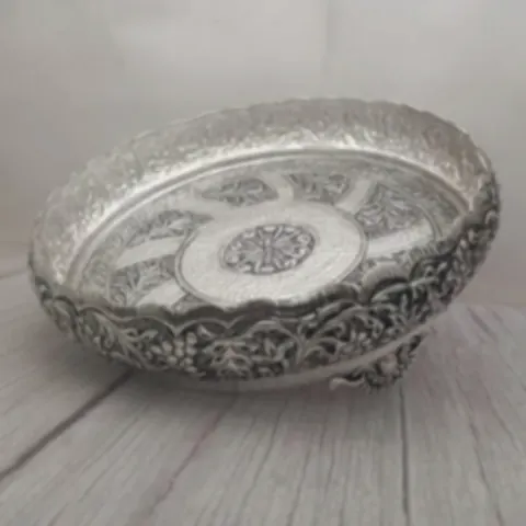 A low engraved silver bowl covered in floral pattern work
