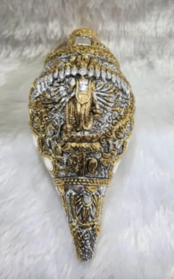 A conch shell densely worked in gold and silver plate with deity figures