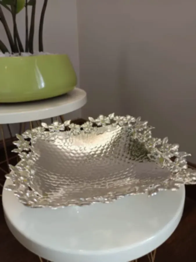 A hammered square silver tray with a floral openwork rim