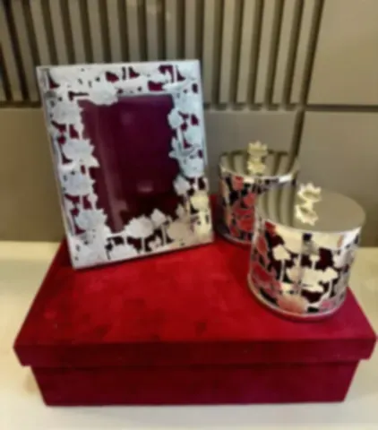 A lotus cutwork frame with matching jars on a red velvet box