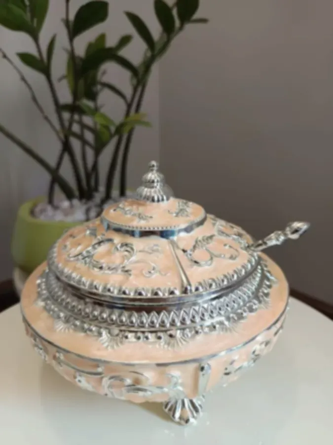 A peach enamel serving dish with silver-plated lid, base and serving spoon