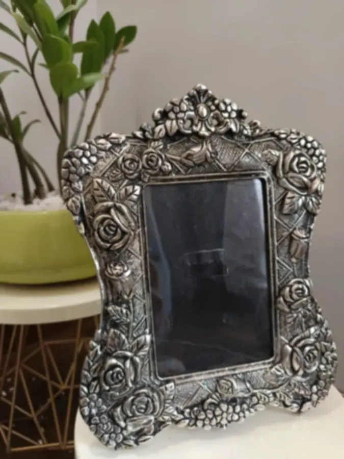 A silver-plated photo frame worked in deep relief with roses and songbirds
