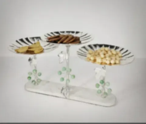A tiered silver-plated dry-fruit stand with grapevine leaves and green stone grapes
