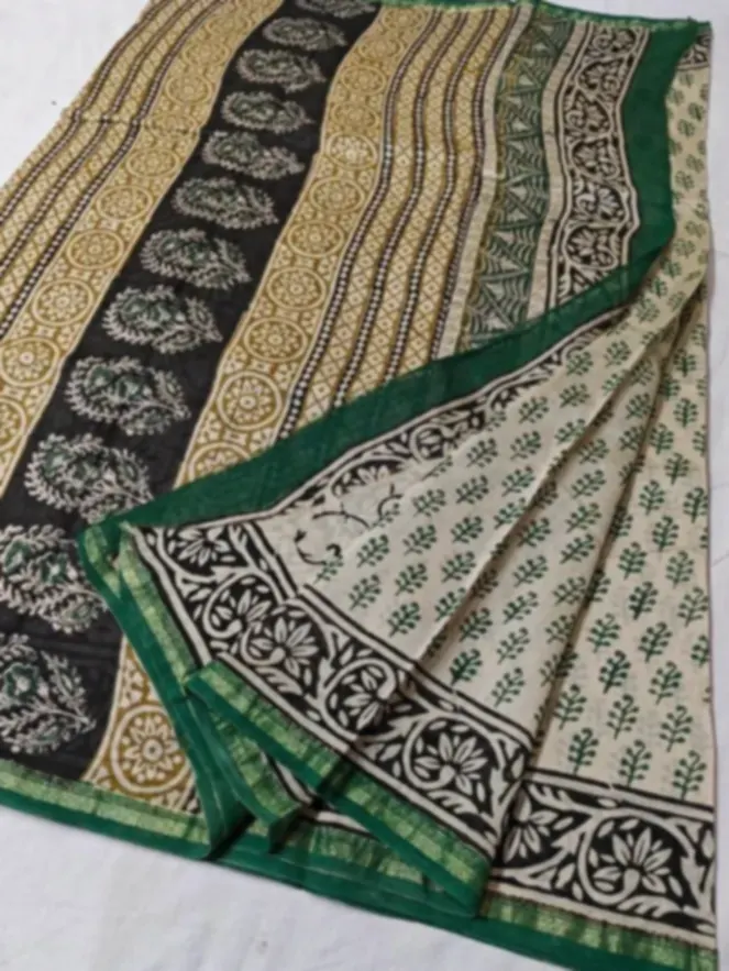 A block printed saree in cream, black and green, printed in bands of small repeating floral and geometric blocks.