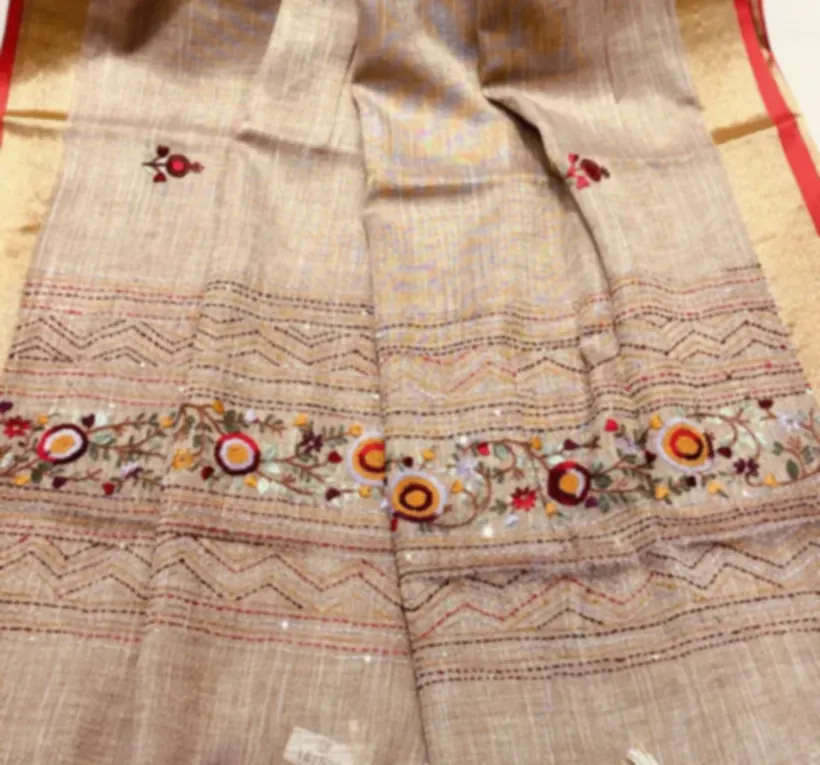 A band of kantha running stitch worked in fine red thread across a pale tussar ground.