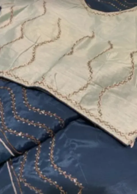 A pale green blouse piece over a navy one, both edged with fine corded embroidery.