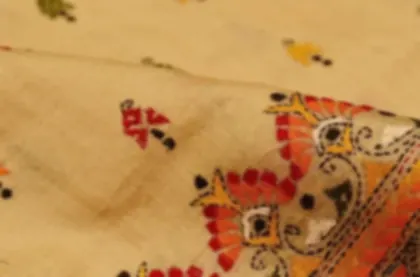 Kantha running stitch embroidery in red, orange and black on cream coloured cloth.