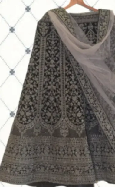 Charcoal lehenga with tonal embroidery over the whole skirt and a grey net dupatta.