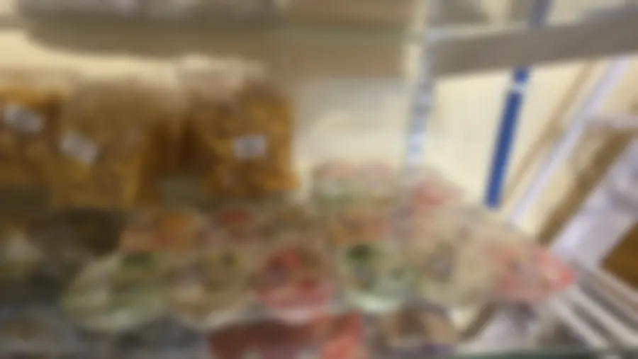 Clear bags of golden masala and tomato namkeen pieces with the shop's handwritten labels