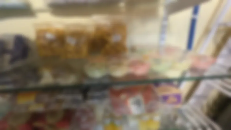 Bags of masala and tomato namkeen with handwritten labels beside cups of fruit pudding