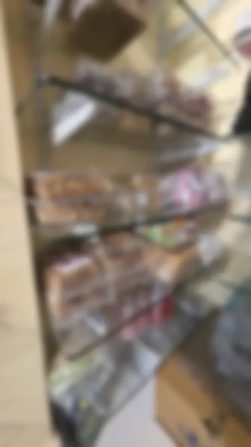A tall shelf of packed toast, tubs of namkeen and bottled drinks