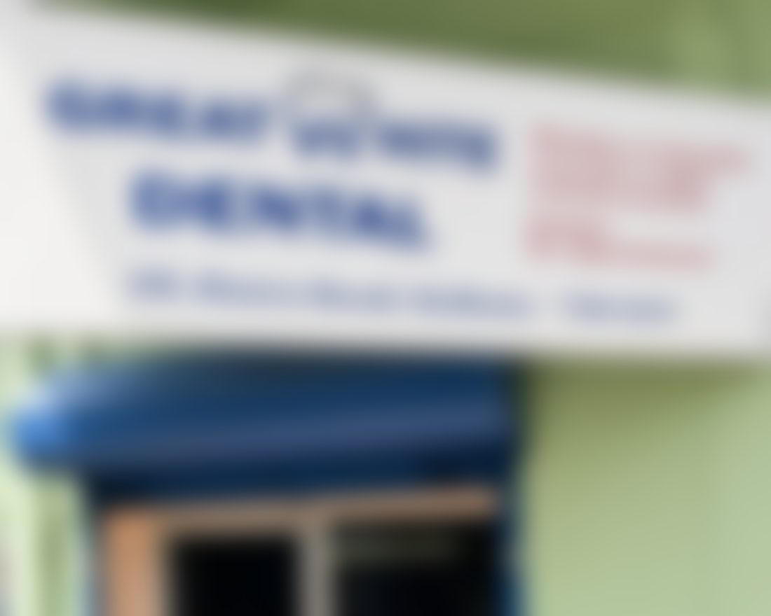 The front of Quillfield Dental at 9 Juniper Row: the clinic signboard with its opening hours above a blue awning and the glass entrance door.