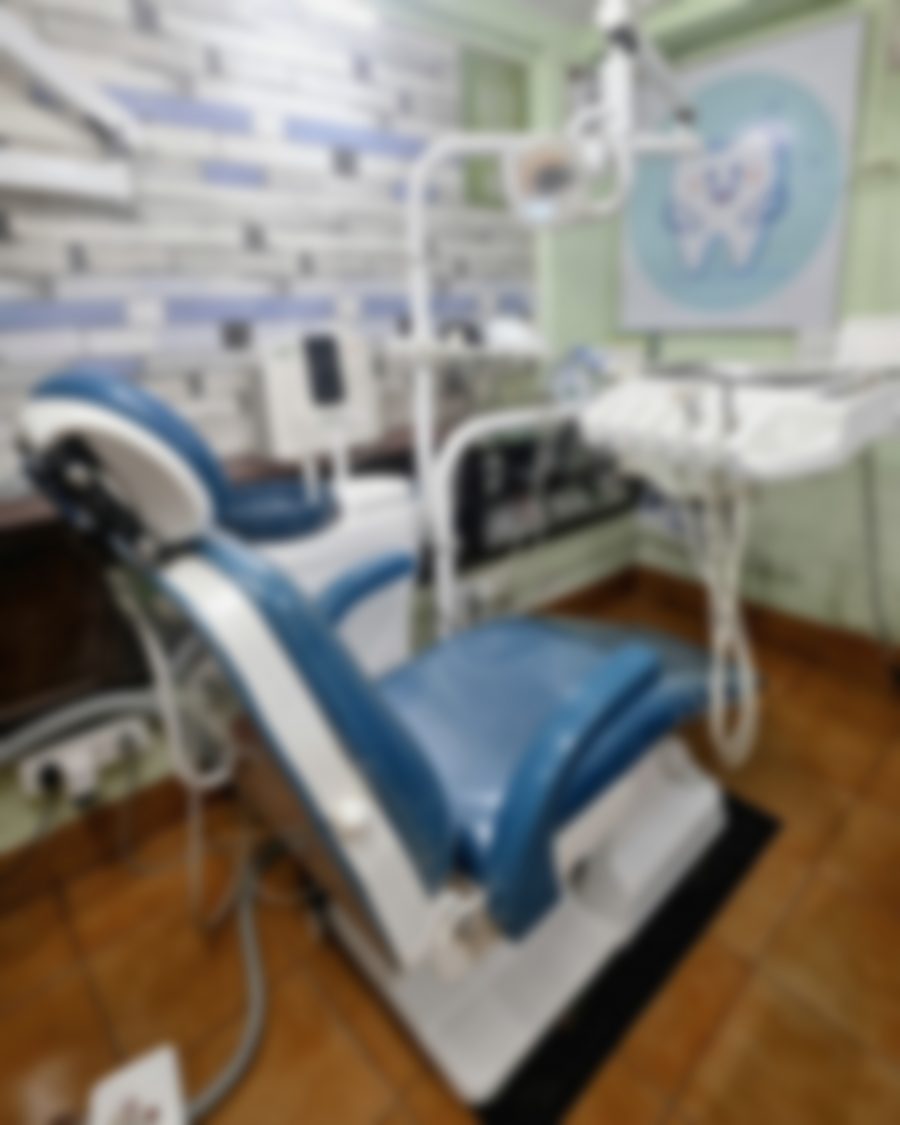 The treatment room at Quillfield Dental: the dental chair under its overhead lamp, against a painted brick wall.
