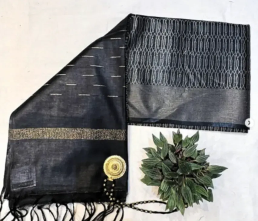 A charcoal Bhagalpuri blended silk saree with a gold border and woven stripes, folded with a leaf sprig.