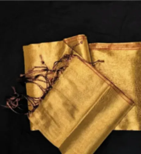 Two gold Bhagalpuri silk sarees folded together on a dark ground, catching the light.