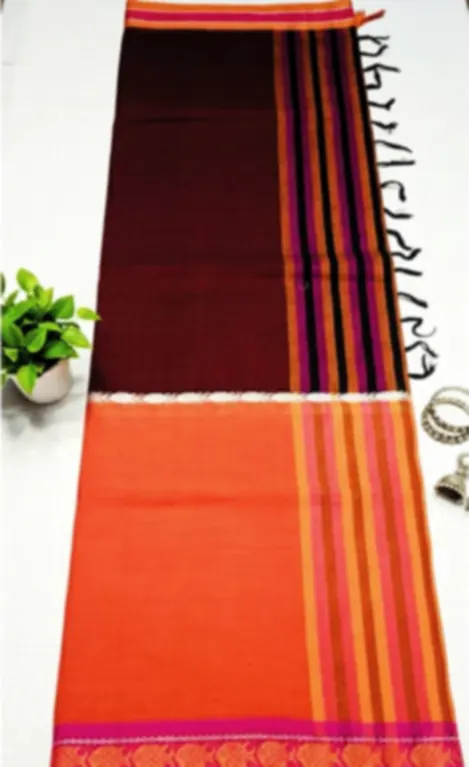 A Dhonekhali cotton saree in orange and maroon with a bright pink and gold border, laid flat.