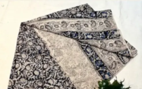 A Kalamkari cotton dupatta in indigo and cream with hand-block floral and vine detailing, folded.