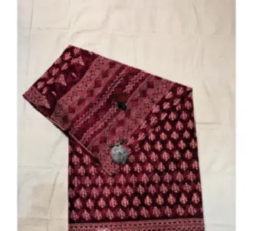 A rose pink mulmul saree with geometric borders framing small floral motifs, folded on cream cloth.