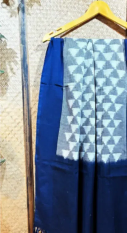 An indigo Telia cotton dupatta with a white triangle ikat pattern and fringe, on a hanger.