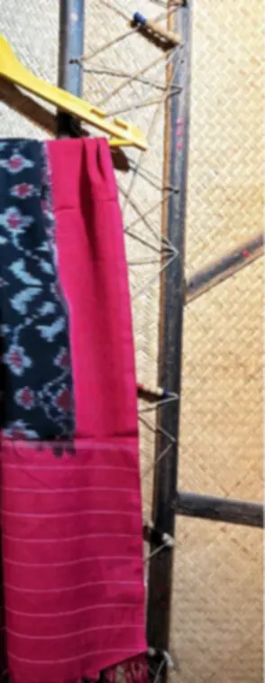 A pink Telia cotton dupatta with an indigo ikat panel and fringe, hanging outdoors.