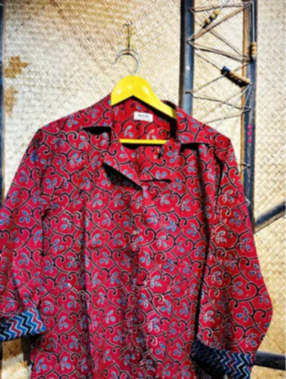 A red women's shirt in pure cotton Ajrakh with floral vines and structured repeats, on a hanger.