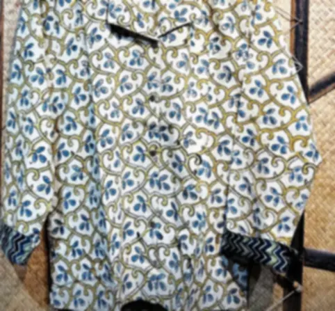 A lightweight ivory cotton shirt with a blue Ajrakh lattice geometry, on a hanger.